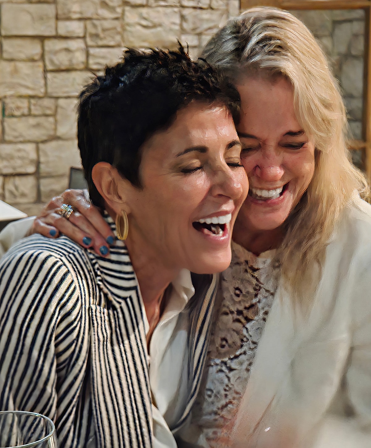 Two women laughing joyfully together.