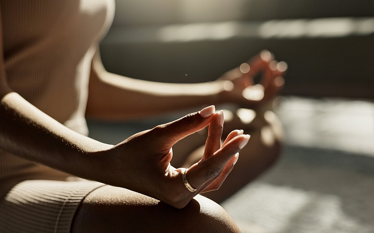 Person practicing meditation in peaceful setting.