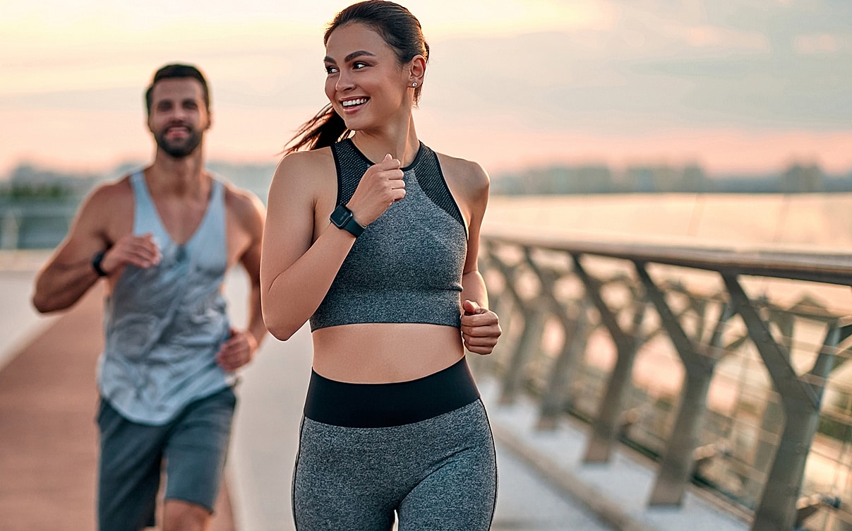 Couple jogging together during sunset.