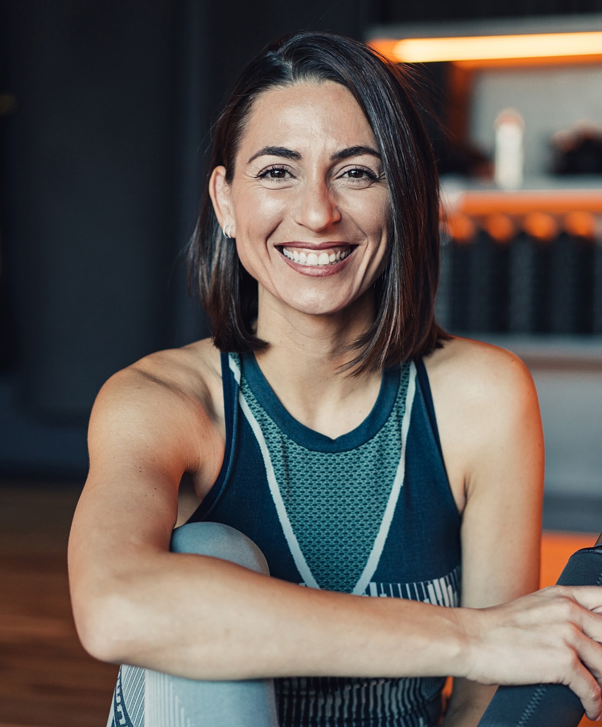 Smiling woman in athletic wear, close-up portrait.