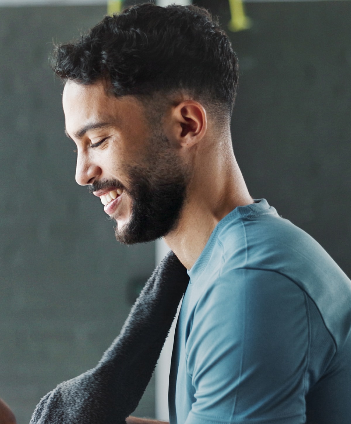 Smiling man with towel after workout session.