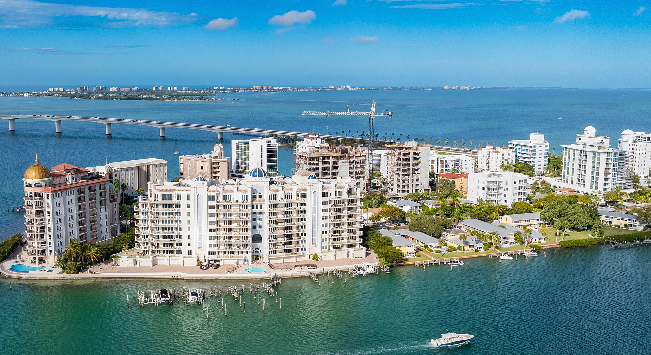 Coastal skyline with buildings and bridge overview.