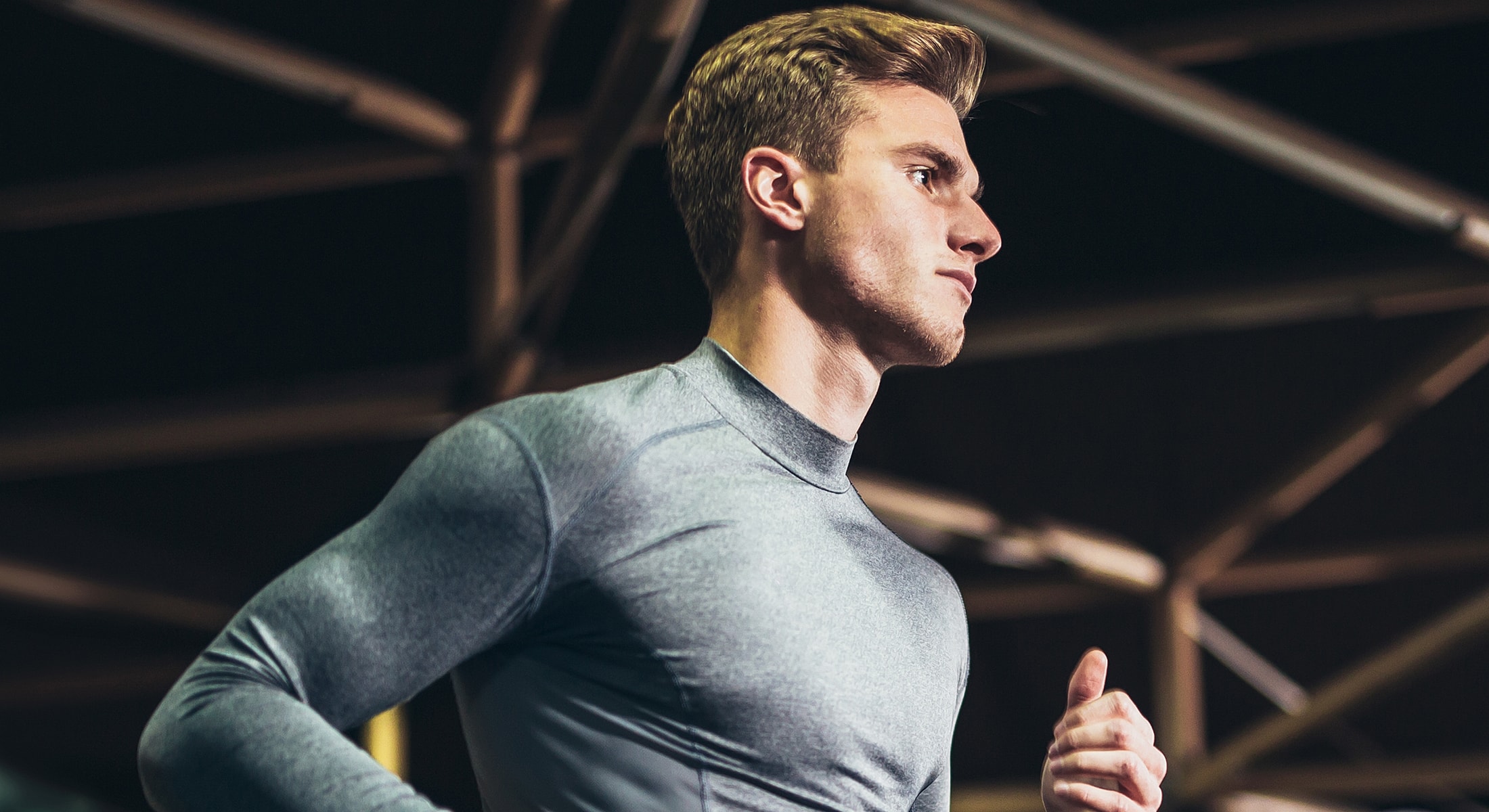 Athletic man running in a gym environment.